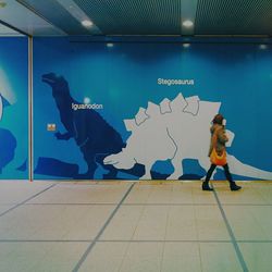 Full length of woman standing against wall