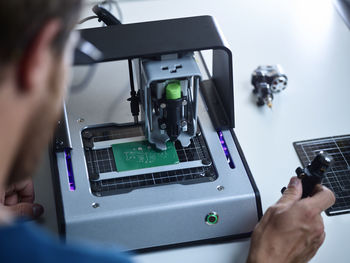 Engineer operating milling machine on circuit board in laboratory