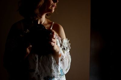 Midsection of woman standing against wall