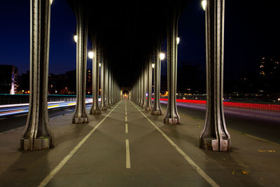 Illuminated road against sky at night