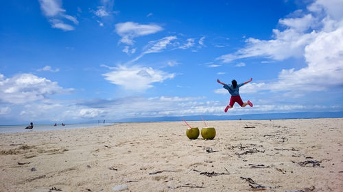 Silhouette of woman jumping on beach