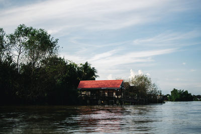 Building by lake against sky