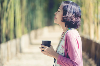 Side view of woman using mobile phone