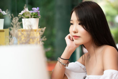 Young woman looking at flower