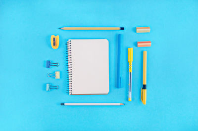Directly above shot of school supplies over blue background