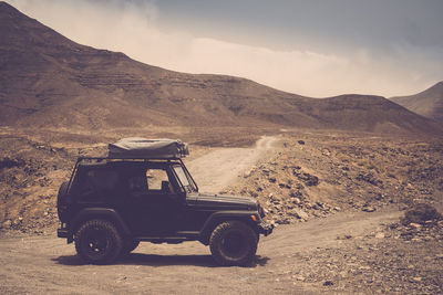 View of car on desert against sky