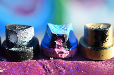 Close-up of multi colored spray paint sprayers on table