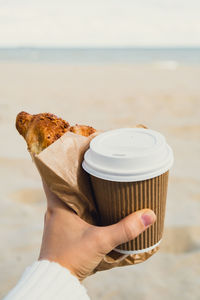 Midsection of woman holding coffee on table