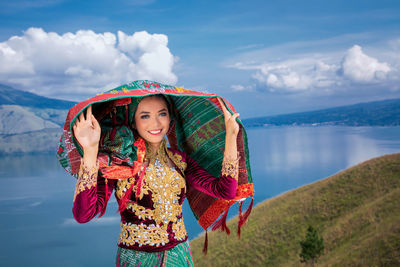 Young woman standing against the sky