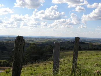 Wooden fence on field against sky