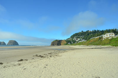 Scenic view of beach against blue sky