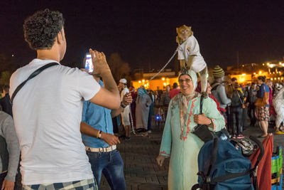 Rear view of people standing at night