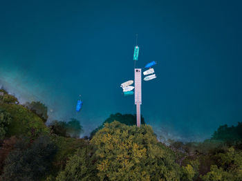 Aerial view of sailboats by pier in sea against trees