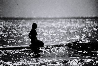 Rear view of woman standing in sea