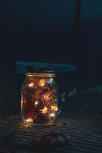 Close-up of illuminated glass jar on table