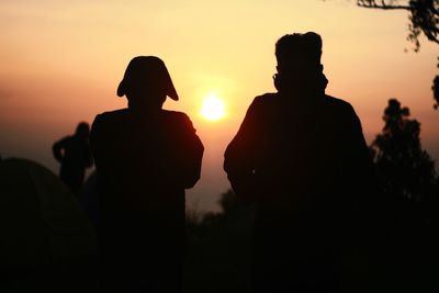 Silhouette people against sky during sunset