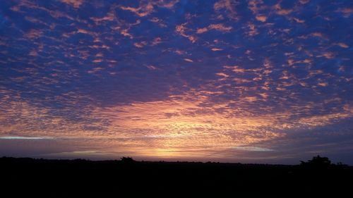 Silhouette of landscape against cloudy sky