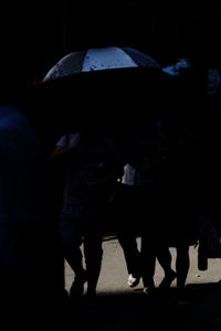 Rear view of people walking in rain