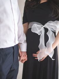 Midsection of couple holding hands