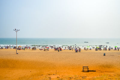 Group of people on beach against sky