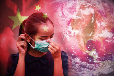 Digital composite image of woman wearing mask with earth and chinese flag