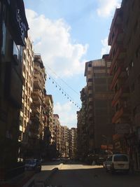 Cars on road against sky in city