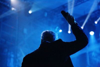 Rear view of silhouette man at music concert