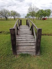 Boardwalk on field against sky