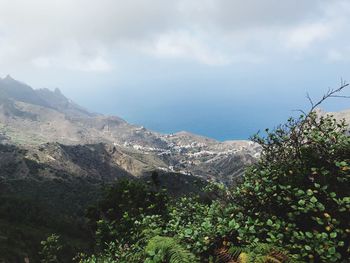 Scenic view of sea and mountains against sky