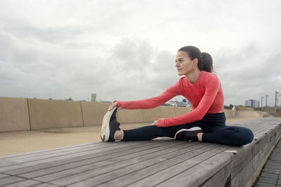 Sporty woman doing leg stretching exercises, outside. outdoor workout.