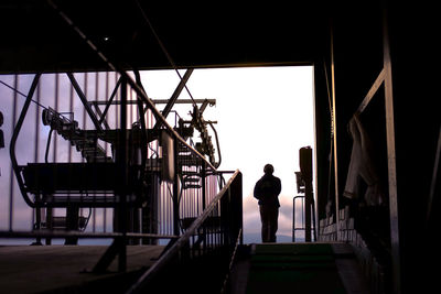 Rear view of silhouette man standing on staircase