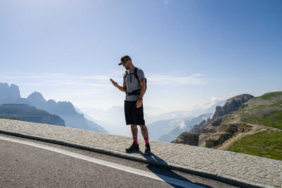 Man using his phone overlooking the mountains