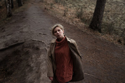 Portrait of young woman standing in forest