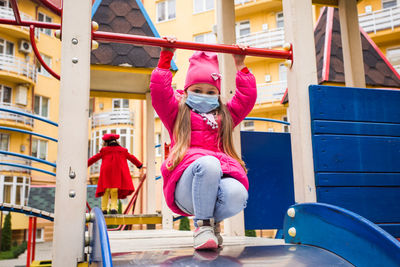 Portrait of cute girl wearing mask playing at playground