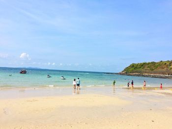 People at beach against sky