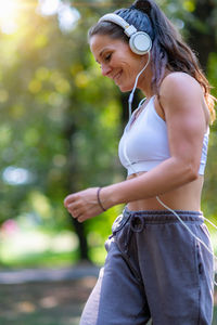Young woman looking away while standing outdoors