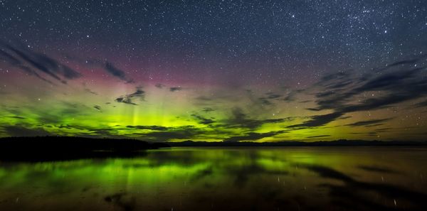 Scenic view of lake against sky at night