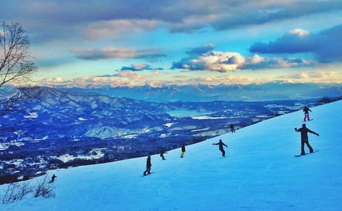 Scenic view of snow covered mountains against blue sky