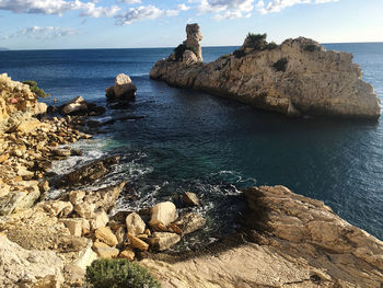 Rocks in sea against sky