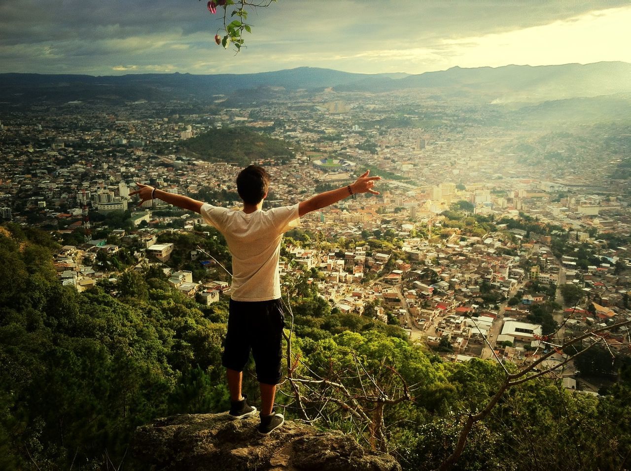 full length, lifestyles, leisure activity, casual clothing, rear view, standing, sky, building exterior, arms outstretched, built structure, tree, architecture, landscape, person, city, outdoors, mid-air, walking