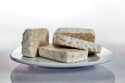 Close-up of bread in plate against white background