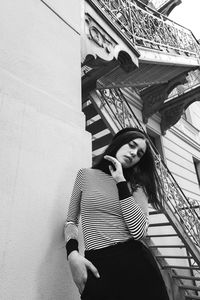 Low angle view of woman standing against building