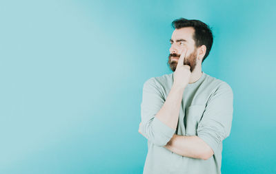 Young woman using mobile phone against blue background