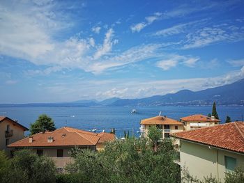 Houses by sea against sky