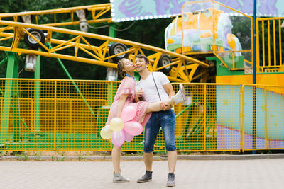 Happy couple in love is having fun at an amusement park in the summer. valentine's day