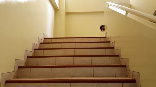 Portrait of girl sneaking on building steps