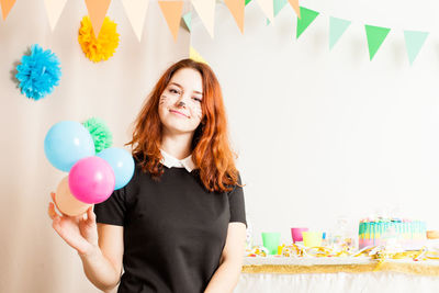 Beautiful young woman with balloons at home