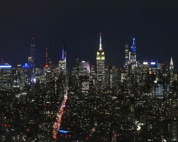 Illuminated cityscape against sky at night