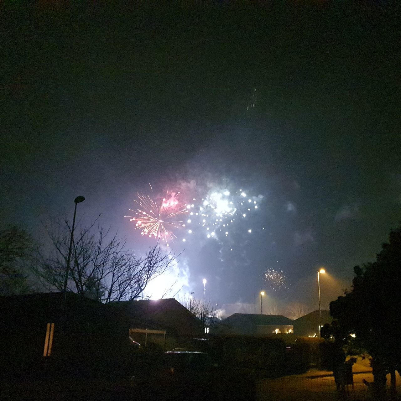LOW ANGLE VIEW OF FIREWORK DISPLAY OVER BUILDING