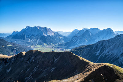 Scenic view of snowcapped mountains against clear blue sky